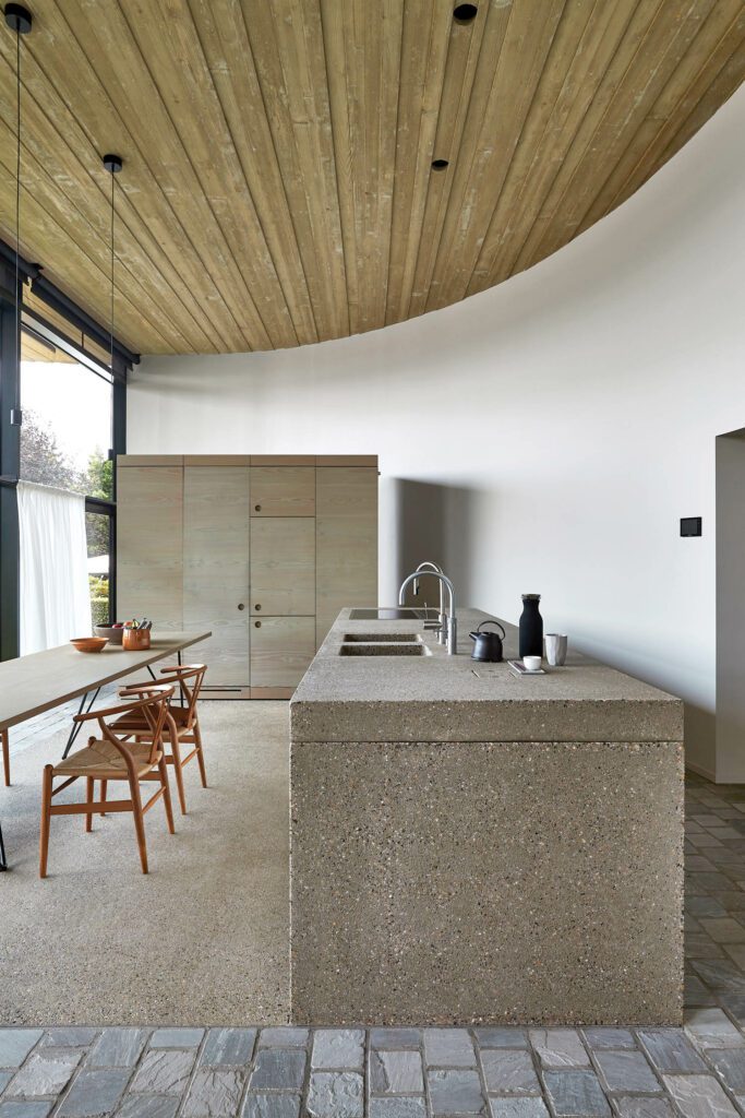 a concrete kitchen with wood panel ceilings