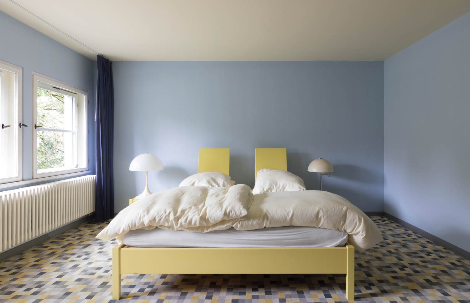 a pale yellow bed in a baby blue room