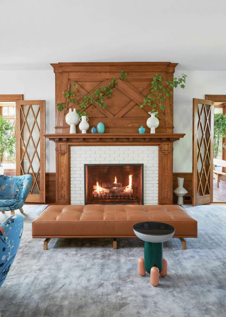 Near the living room fireplace, with original oak millwork, a Jaime Hayon side table cozies up to a leather daybed.