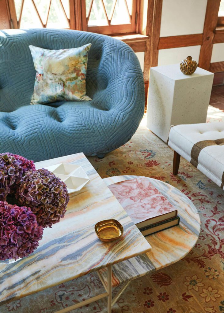 In the sunroom, a Bouroullec Brothers Ploum sofa joins an Iacoli coffee table featuring a custom top in onyx from Artistic Tile.