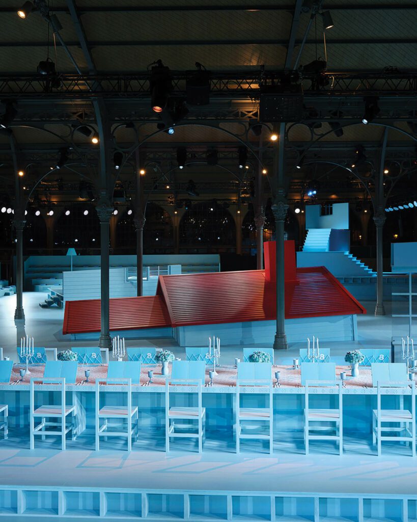 A blue table surrounds the dream-house installation.