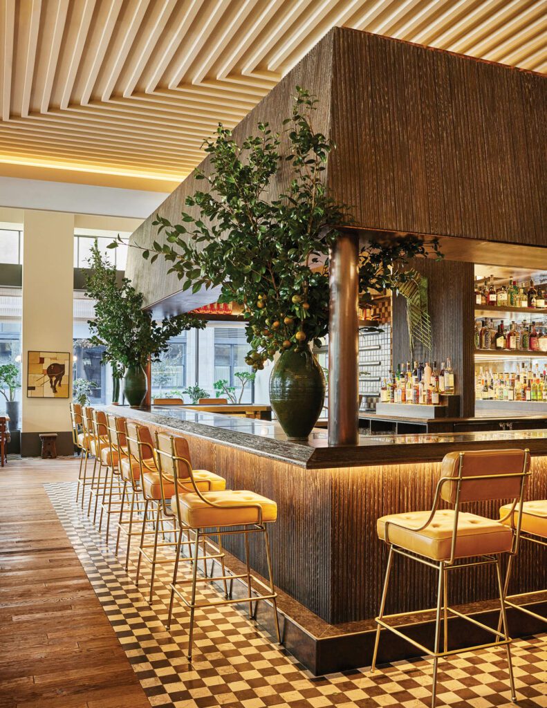 Custom stools line the Caldo Verde bar, built of copper, granite, and ribbed oak that’s been ebonized, cerused, and wire-brushed; floor tiles are also custom.