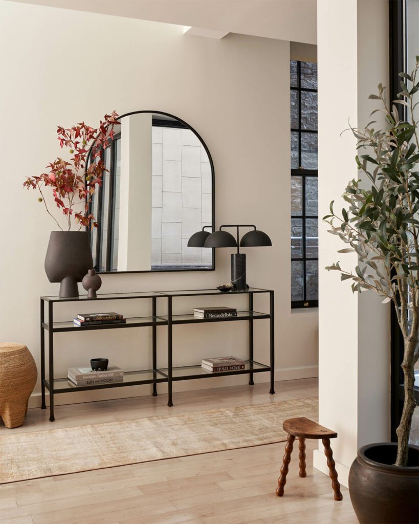 In the entry, Casa Gitane ceramics and a CB2 table lamp are placed in the client’s console table. The Shades of Light mirror, Palecek bulb stool, Bente vintage runner and Etsy vintage stool complement the warm atmosphere.