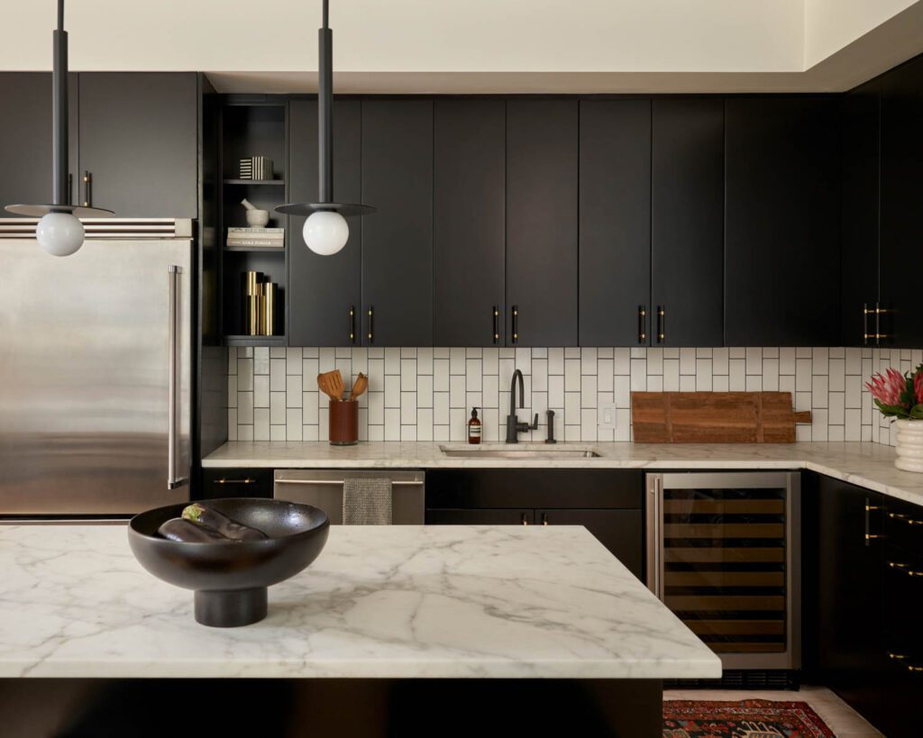 The kitchen with a Rejuvenation faucet and Tile Bar backsplash features Kelly Wearstler pendant lights.