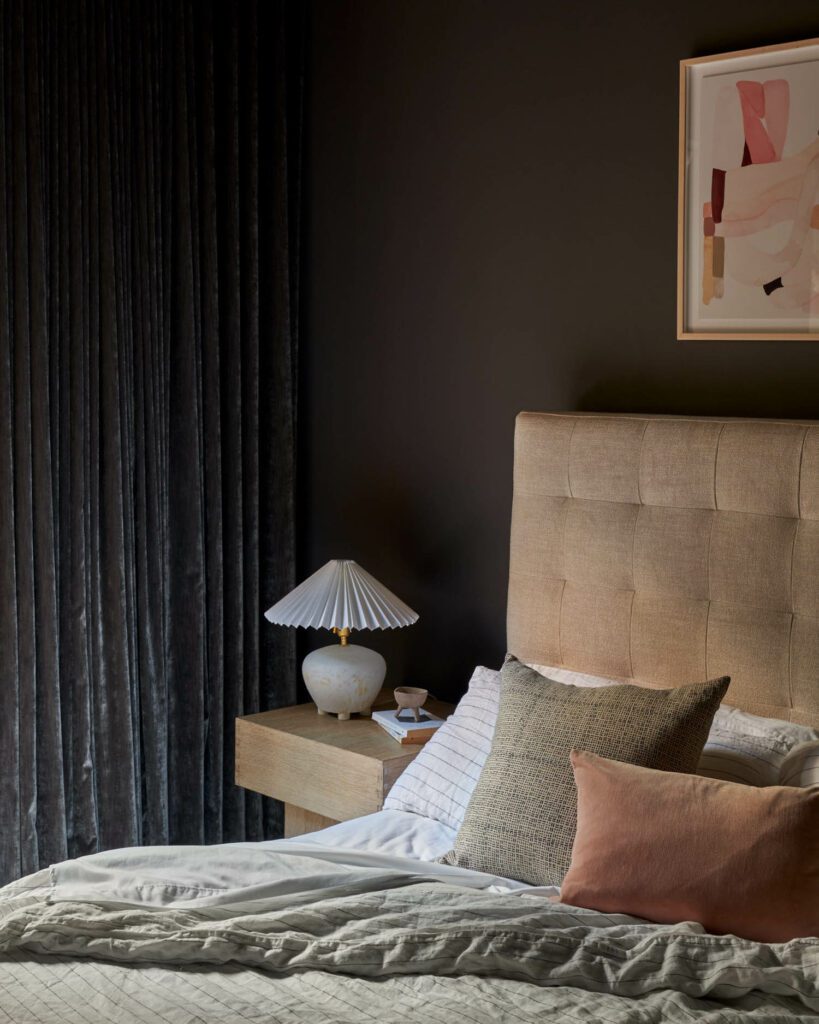 In the primary bedroom with an artwork by Jenny Pennywood, a Notary Ceramics table lamp sits on an Anthropologie nightstand.