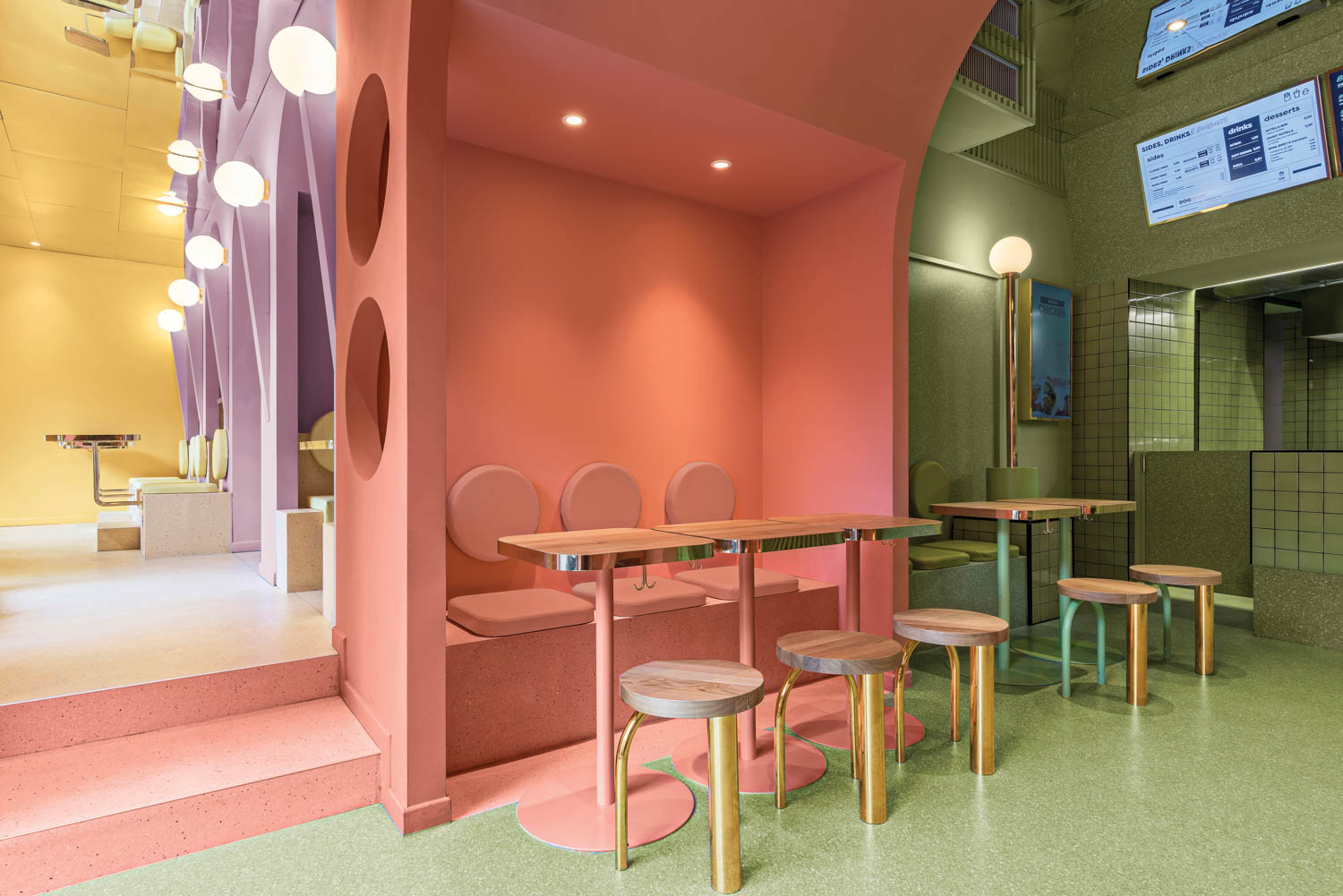 a seating area in pink and green at Bun Burgers Milan