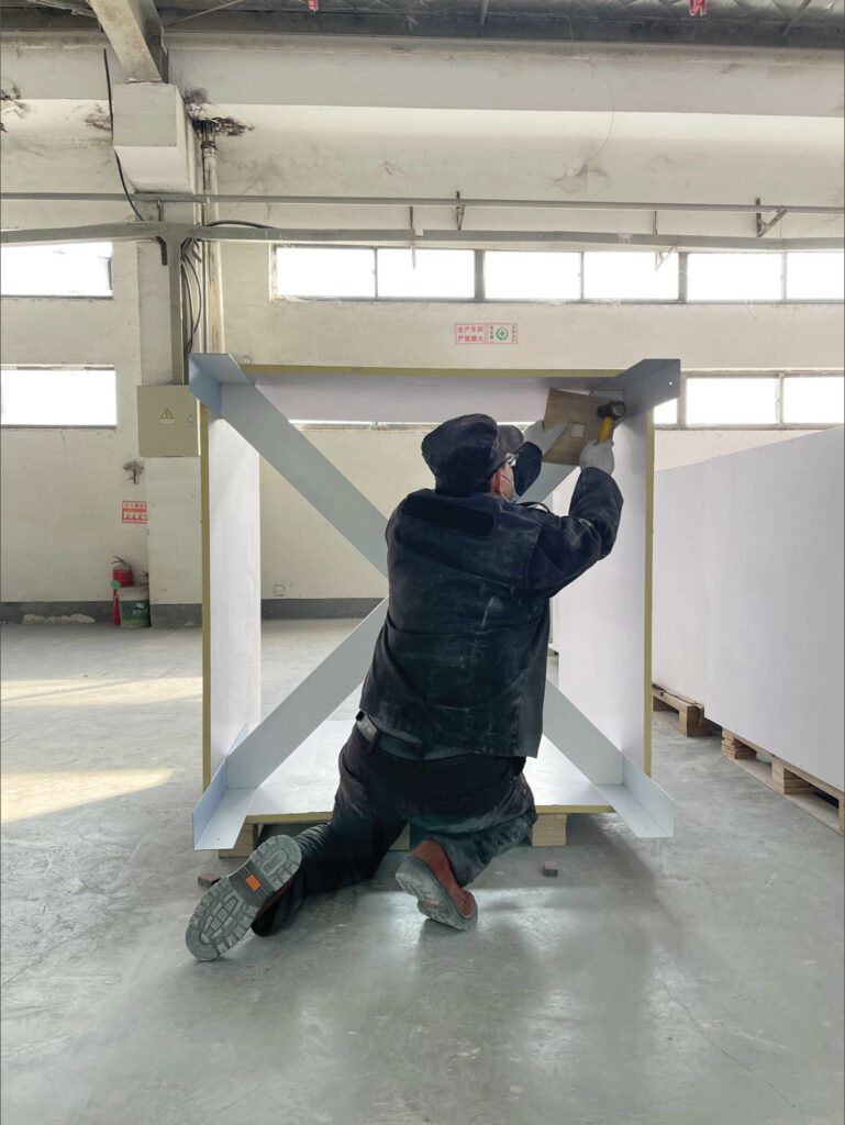 In a Shanghai factory, a fab­ricator installs a supporting steel structure to test the modules’ stability.