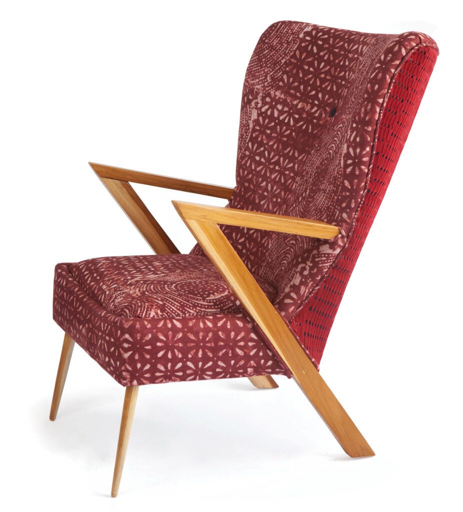 The Àdùnni Pupa armchair by Nigerian furniture brand Ilé Ilà, upholstered in Adiré, a fabric used in everyday wear, and Asò-oké, one reserved for ceremonial occasions.