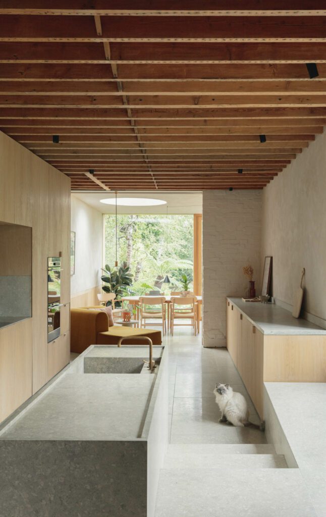 The kitchen includes a Grassi Pietre island and sink, leading into a dining area with a Carl Hansen table and chairs.