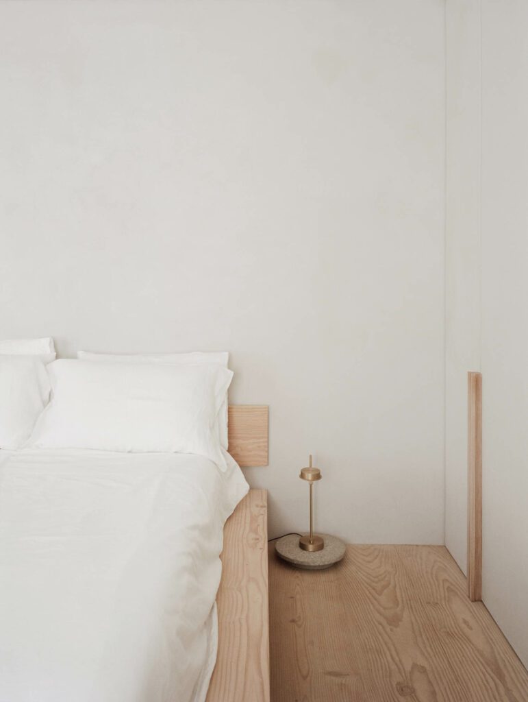 A Wästberg floor lamp illuminates the custom bed in the primary bedroom. 