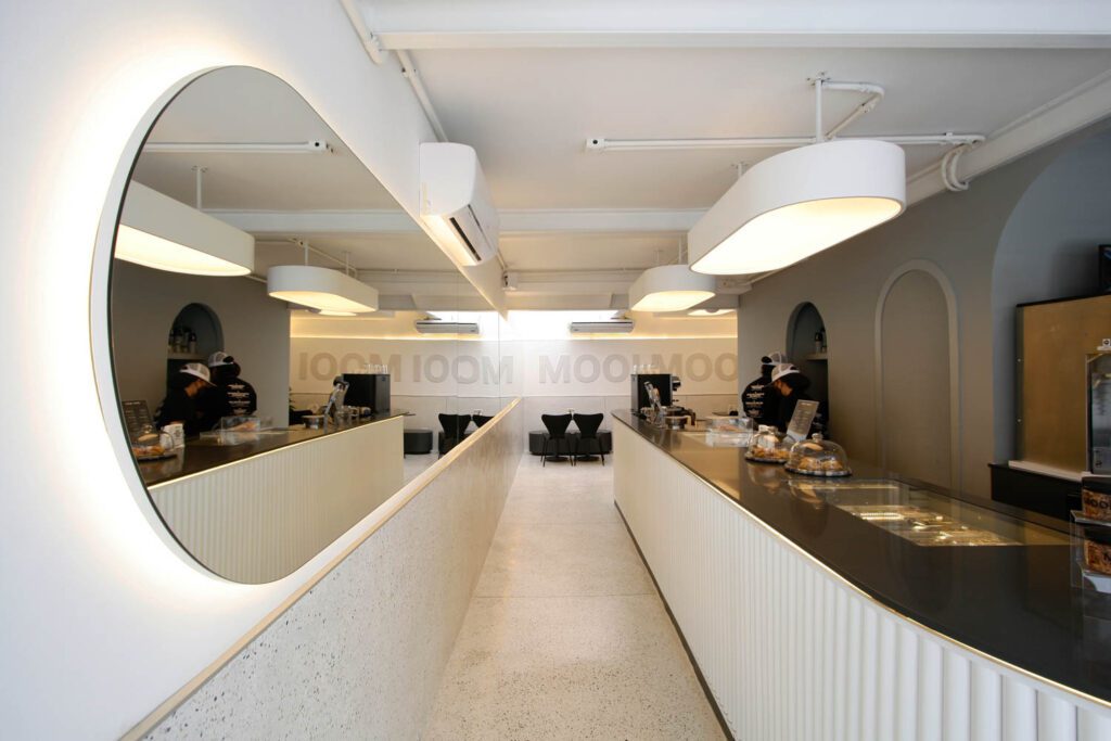 Marcenaria Piva crafted the custom pendants illuminating the counter, which is fronted by plastic tubes painted a frosty white.