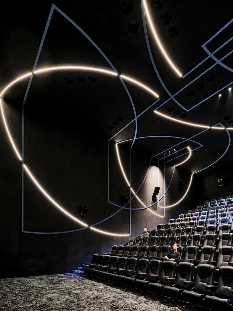 Inside the theater, neon lights form patterns across the walls and ceiling. 