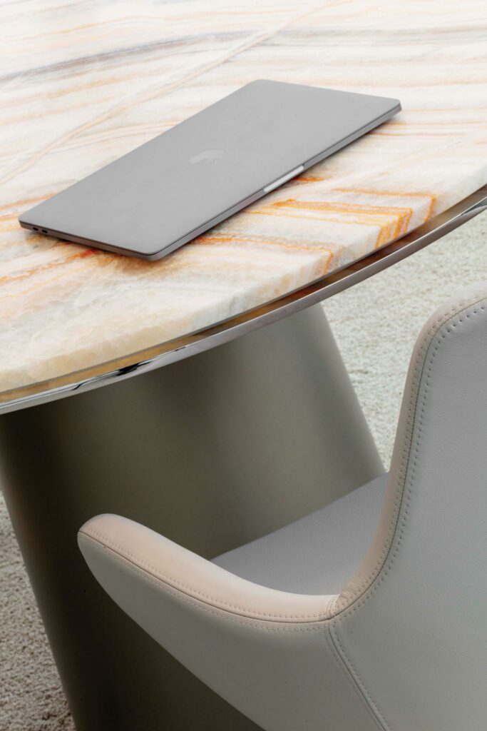 An onyx-topped table and an Arne Jacobsen Little Giraffe chair furnish a meeting room.