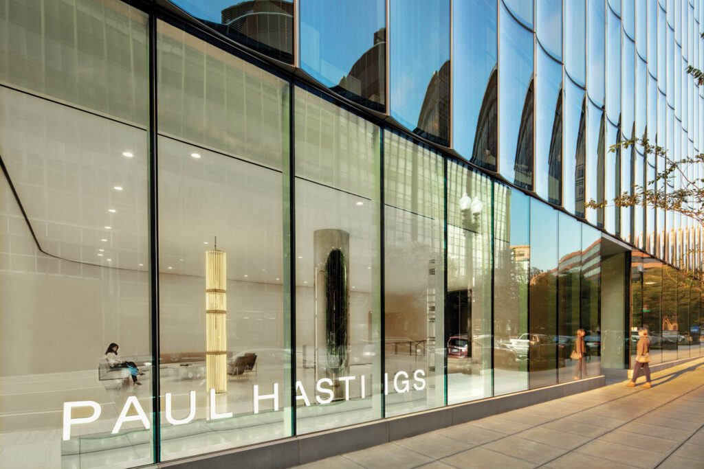 The glass curtain wall allows the law-firm lobby to function like a public gallery, with the Wyn Evans installation visible to passersby.