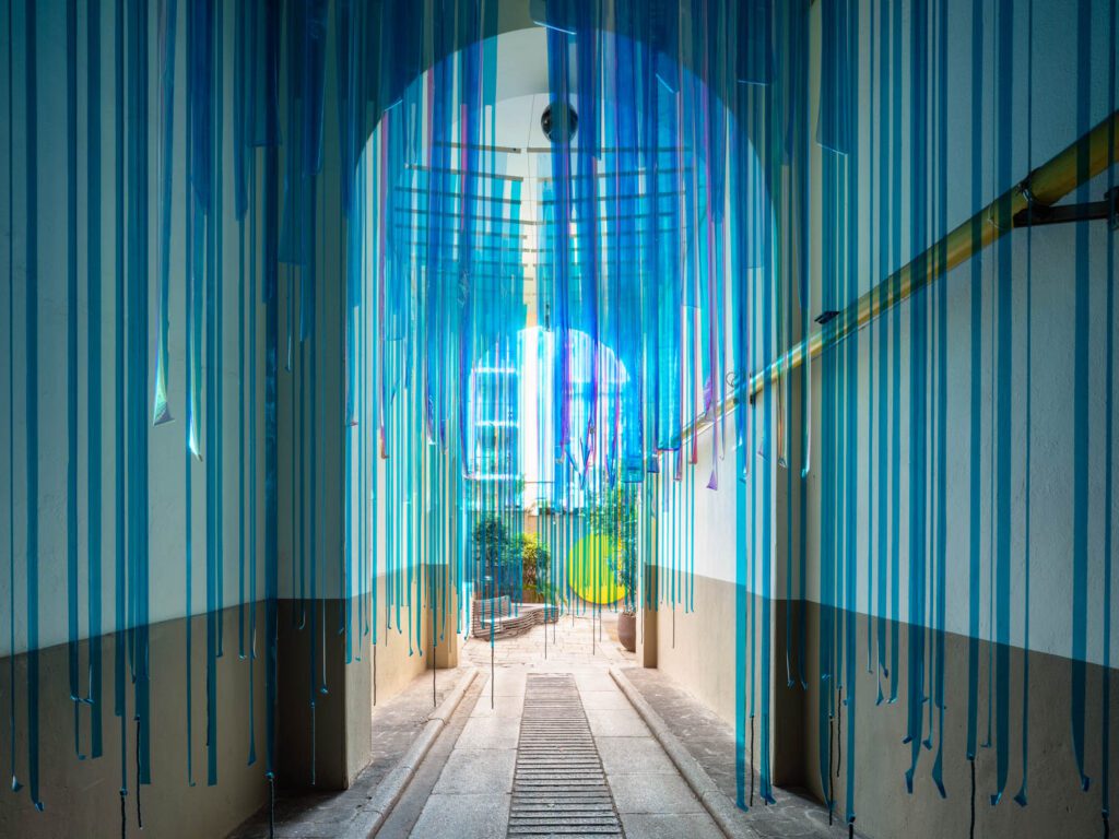 Filled with suspended vinyl tubes, the Rain Room foyer leads to the courtyard, its disk indicating the sun. 