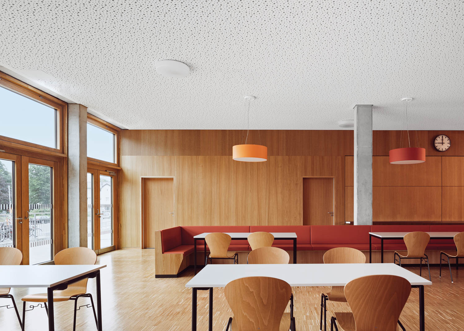 a red booth surrounded by wooden chairs