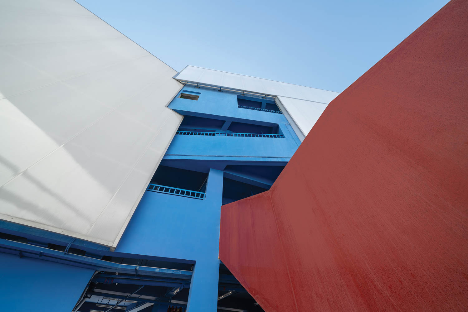 blue stairs poke out between red and white exterior walls