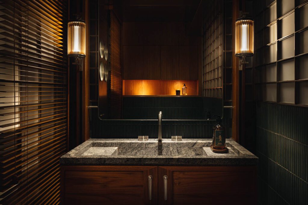 Moody lighting creates intimacy in a bathroom, with a faucet by Waterworks.