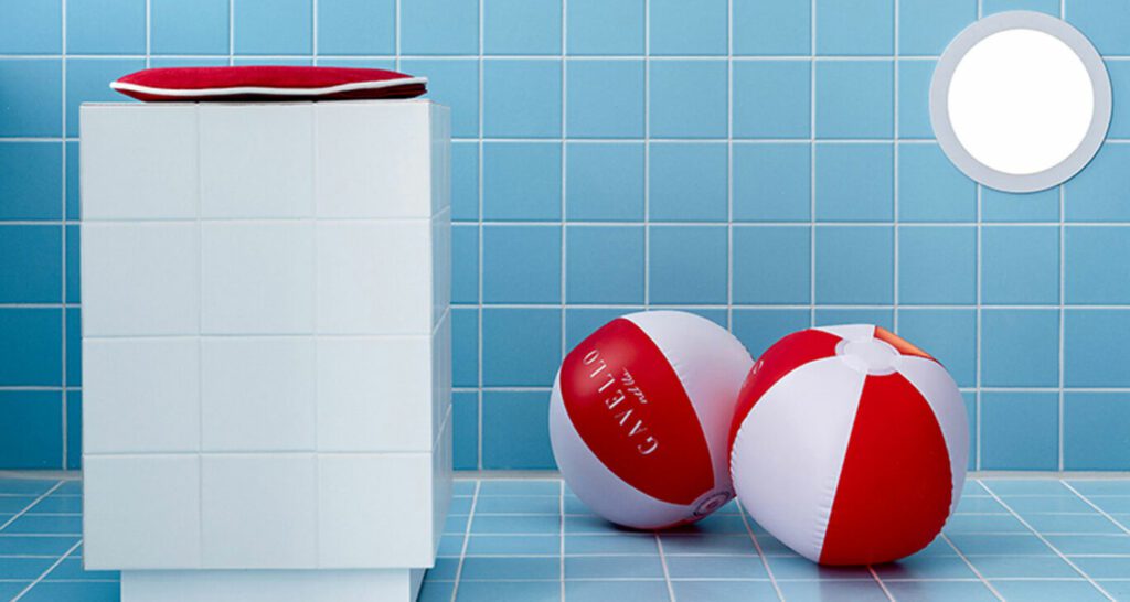 two red and white beach balls in front of a blue tiled wall