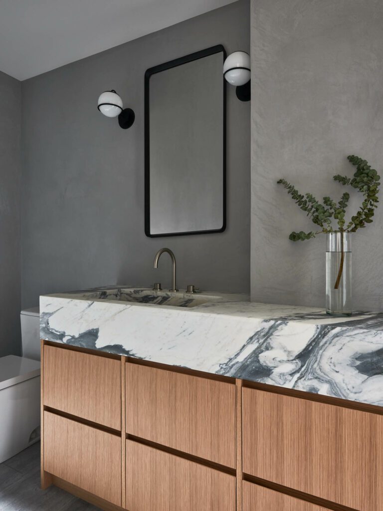 In the main bathroom, Astep sconces frame a Menu mirror; the vanity is white oak veneer and BAS Stone Arabascato Ovulato Marble.