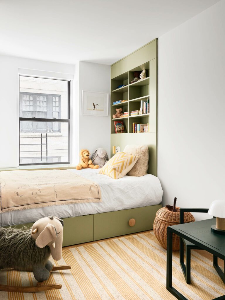 The second kid’s bedroom includes RBW sconces, a bedside lamp by &tradition, and a bright rug by BD Fine.