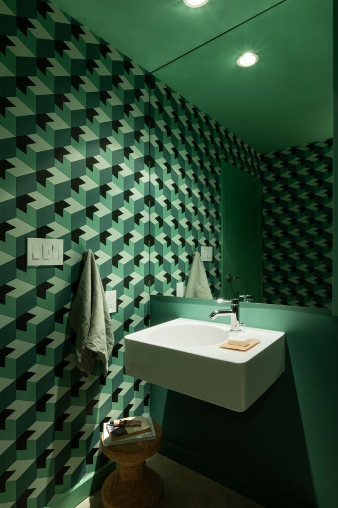 A vibrant green and black wallcovering features geometric prints for a hypnotic effect in the bathroom. 