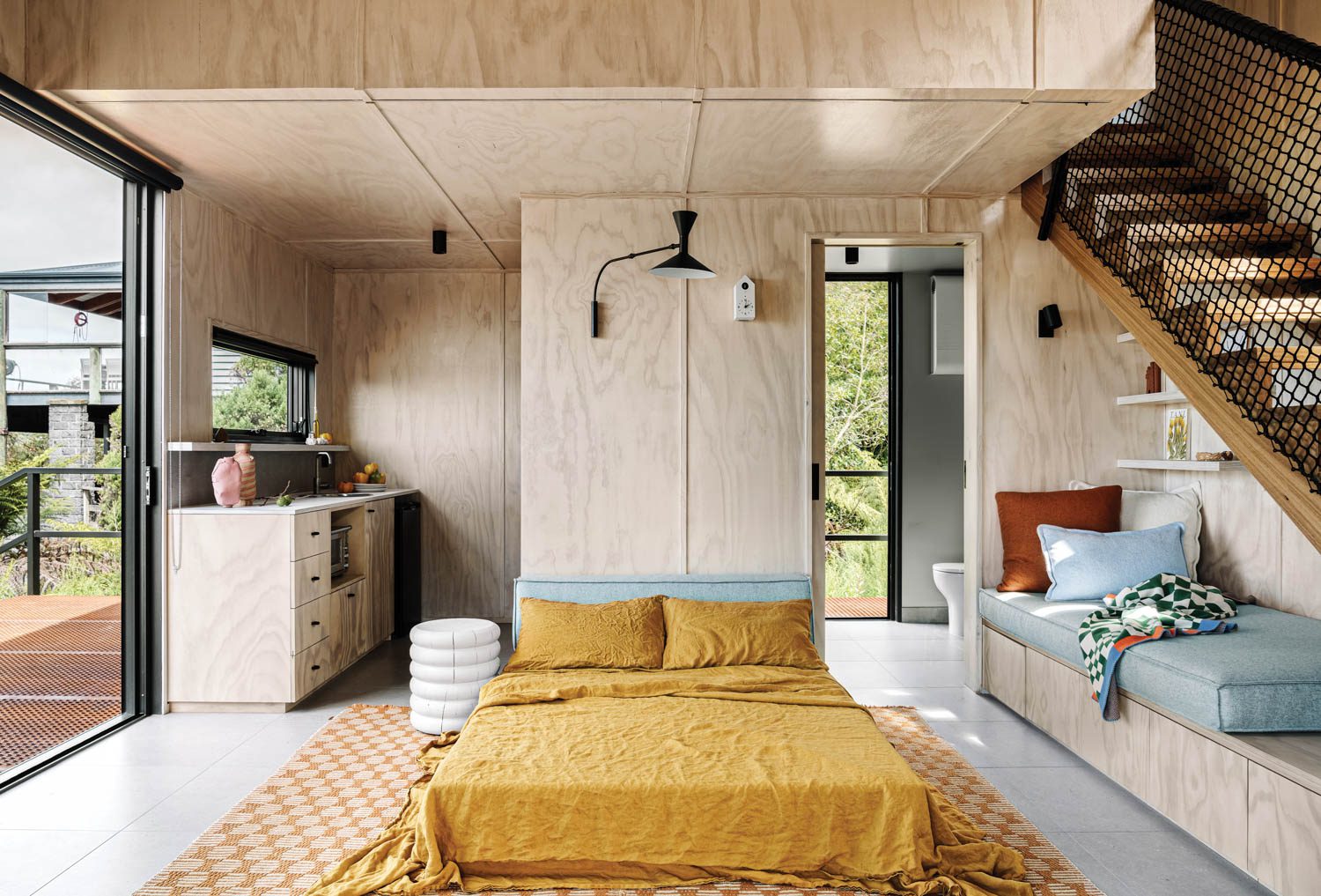 a bed with yellow bedding in the center of the room