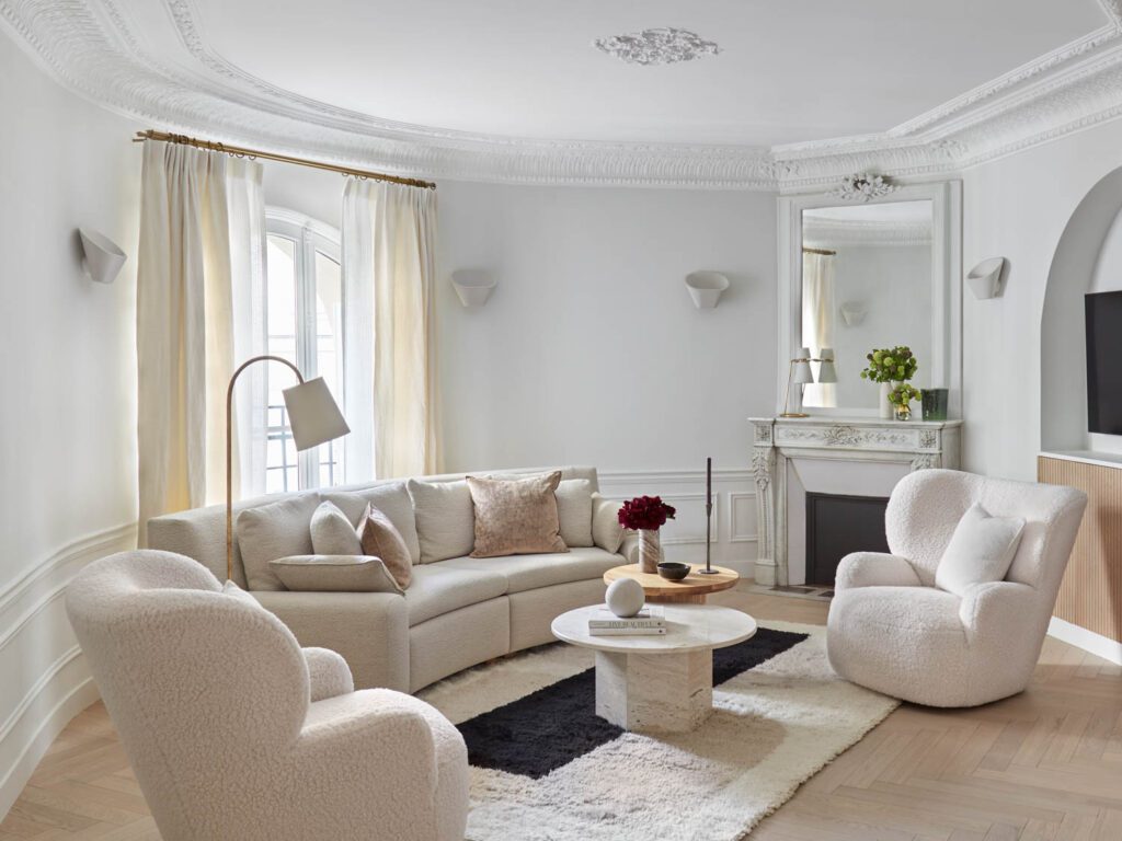 The living room includes Aplomb wall sconces by Foscarini, a custom sofa by Dedar Fabrics, and arm chairs by Paola Navone.