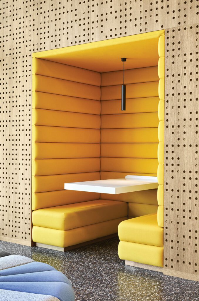 a yellow upholstered alcove with a white table