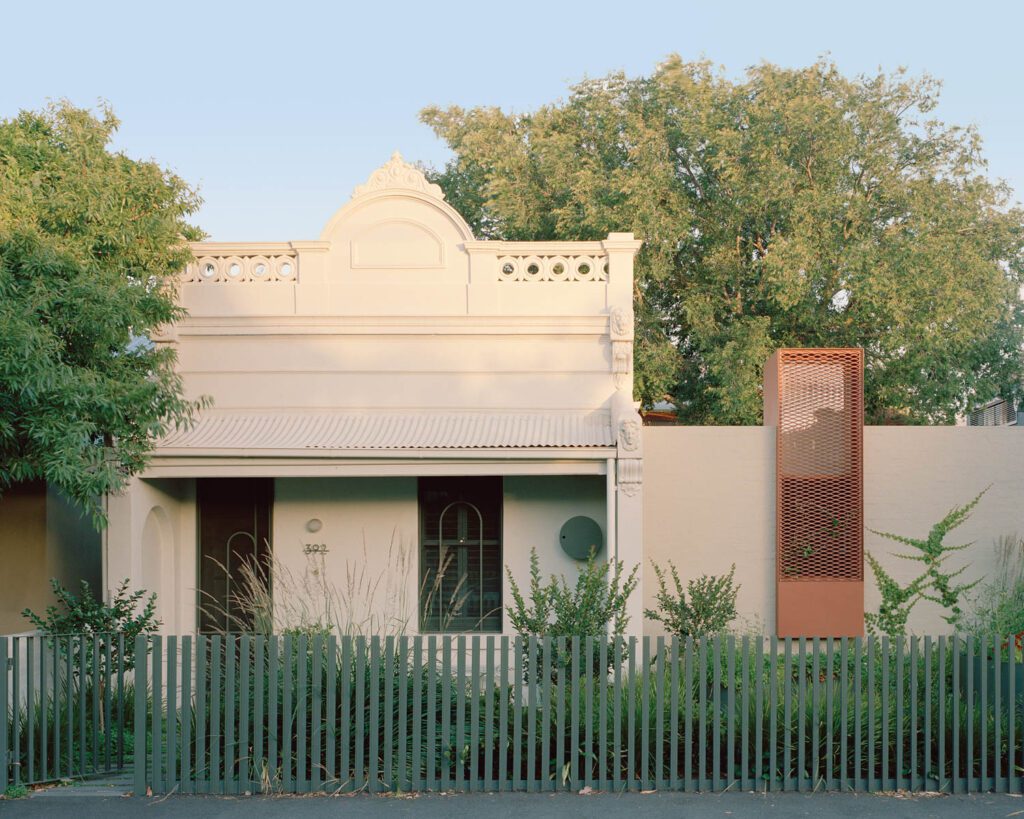 The coloration of the new addition, its window screened in brown-painted metal mesh, was matched to that of the original Victorian terrace house on the left.