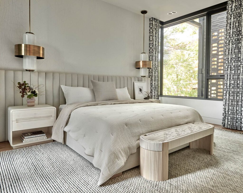 A custom bed and pair of tables define the second floor’s primary bedroom