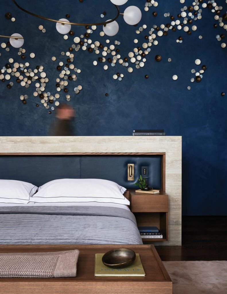 In the primary bedroom, a ceramic artwork by Jennifer Prichard hangs above the bed’s leather-and-limestone headboard.