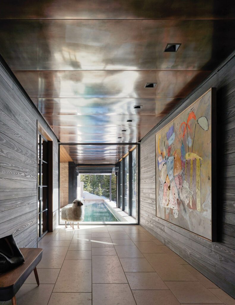 A bronze-and-wool sheep statue stands in a hallway with a copper ceiling; the storage bench is by Jake Whillans. 