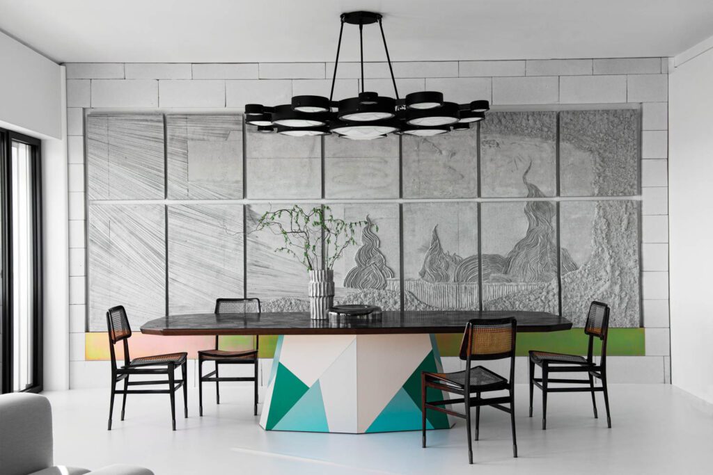 Joaquim Tenreiro chairs furnish the dining area, presided over by Luca Monterastelli’s site-specific concrete bas-relief.