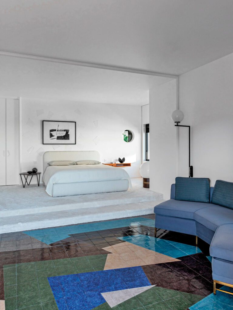 A Gio Ponti side table and Gae Aulenti floor lamp, both vintage, furnish the primary bedroom, with Giulio Paolini’s Exil du cygne; the floor installation is a collaboration between artist David Tremlett, Galleria Alfonso Artiaco, and tile supplier Galleria Elena.