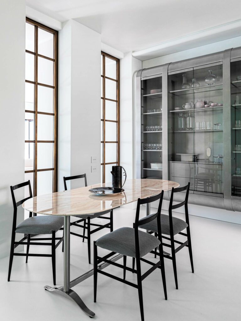 The kitchen’s Pirellone table and Superleggera chairs were both designed by Gio Ponti, and the custom steel cabinetry by dell’Uva.