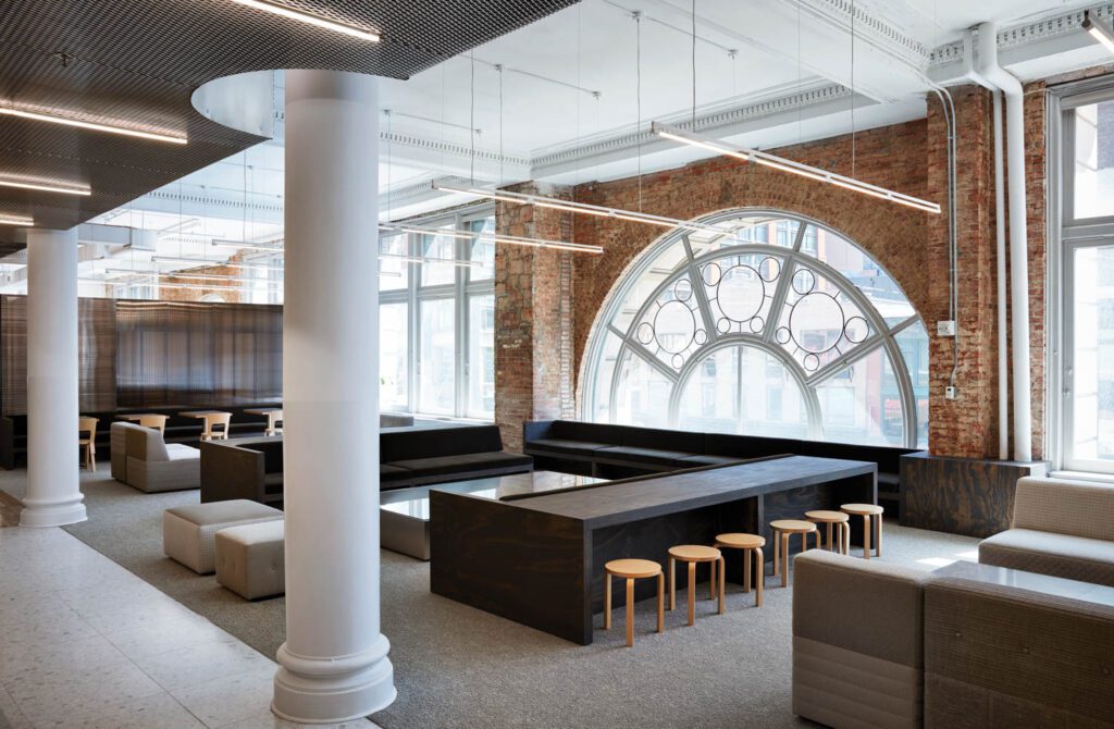 a multifunctional lobby dominated by the building’s original beaux-arts windows, which, along with the exposed brick,