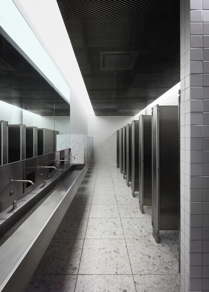 Aluminum metal mesh, stainless steel, and terrazzo in a restroom. 