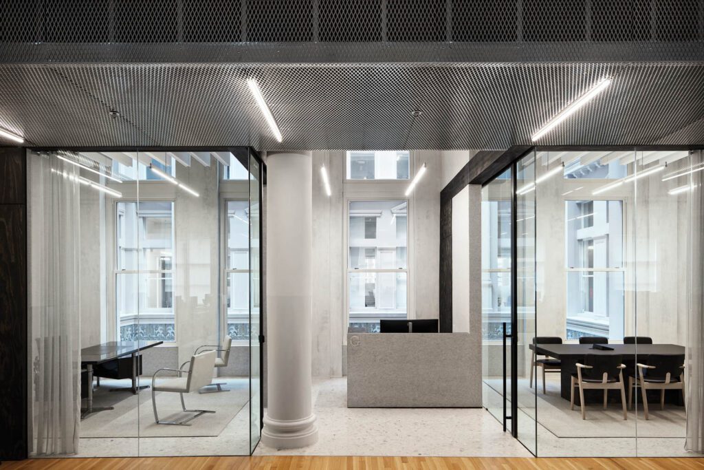 A felt-clad reception desk stands between an office and a conference room in the CEO suite.