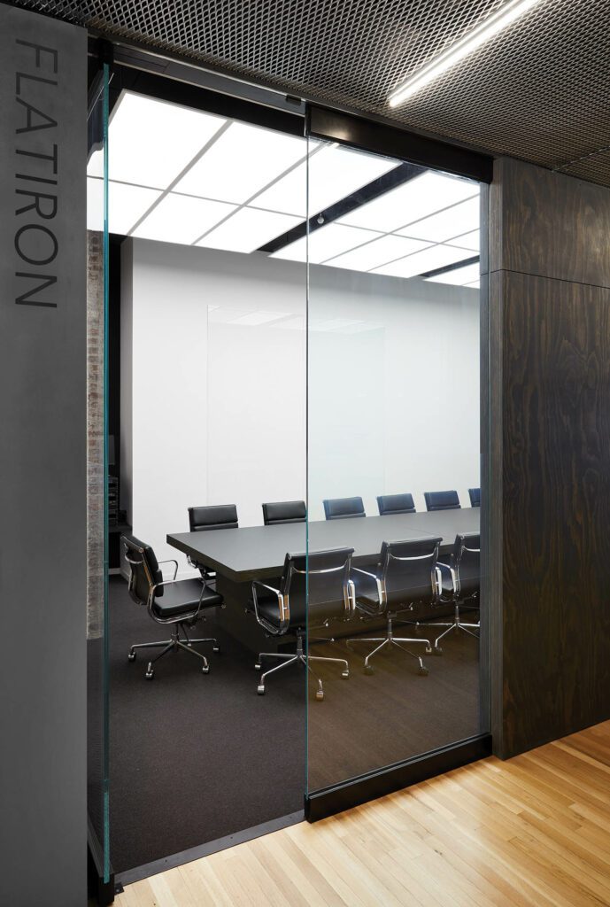 LED ceiling panels, a custom table, and Charles and Ray Eames chairs in the large conference room.