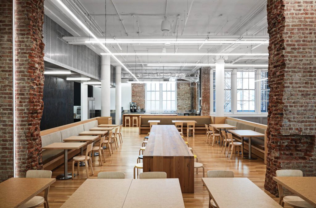 White oak flooring continues into the café, which features rough-edge brick walls, custom banquettes and tables, and more Aalto chairs and stools.