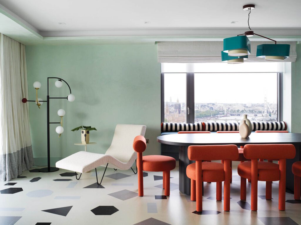 The dining area, with a Greta Grossman GMG chaise lounge and Gropius CS1 chairs surrounding a custom table, boasts enviable views of the Thames. 