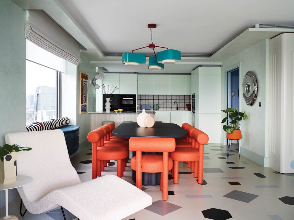 A chandelier by Utu Soulful Lighting illuminates the dining area, with linoleum flooring in a custom pattern that riffs on terrazzo.