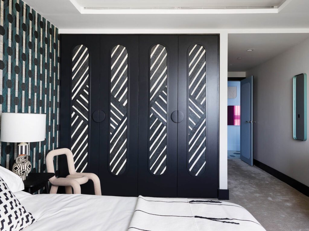 In the second guest room, the designers covered the closet’s existing doors with lozenge-shape graphic illustrations.