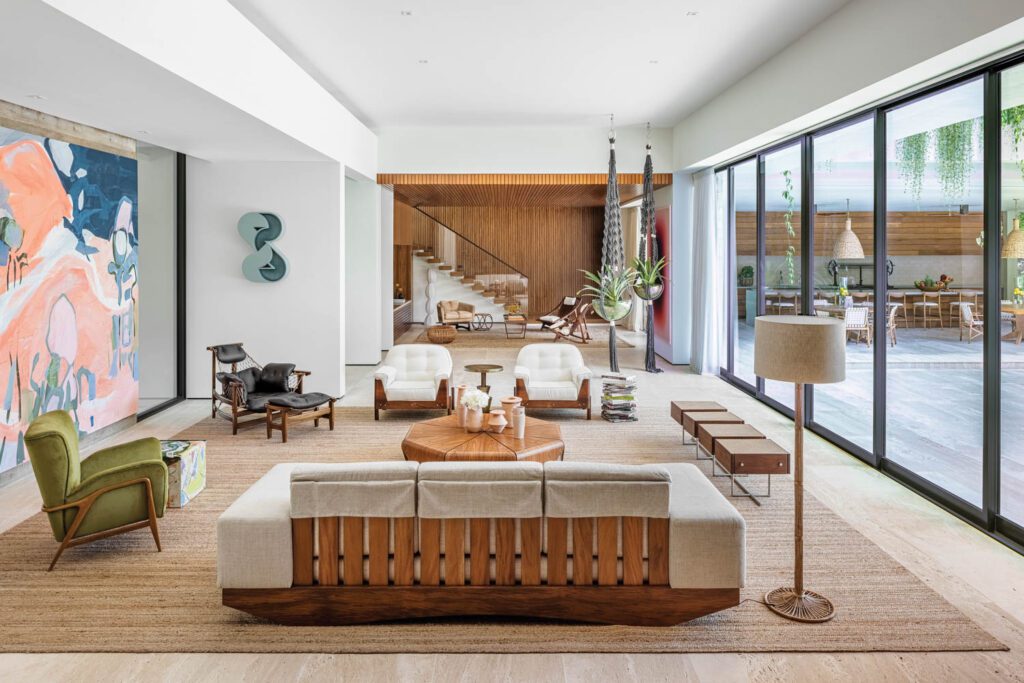 the main living area with a Janaina Tschäpe painting, Amir Nikravan sculpture, Jorge Zalszupin coffee table, and Jean Gillon armchairs