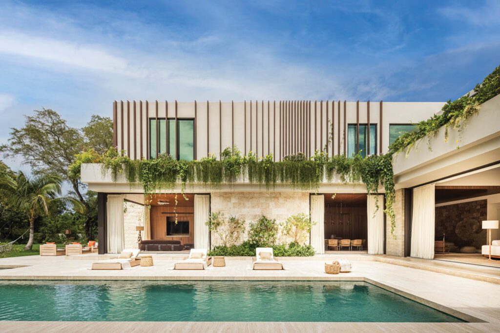 Aluminum louvers on the stucco-clad second story provide privacy while serving as trellises with floor-to-ceiling pocket doors