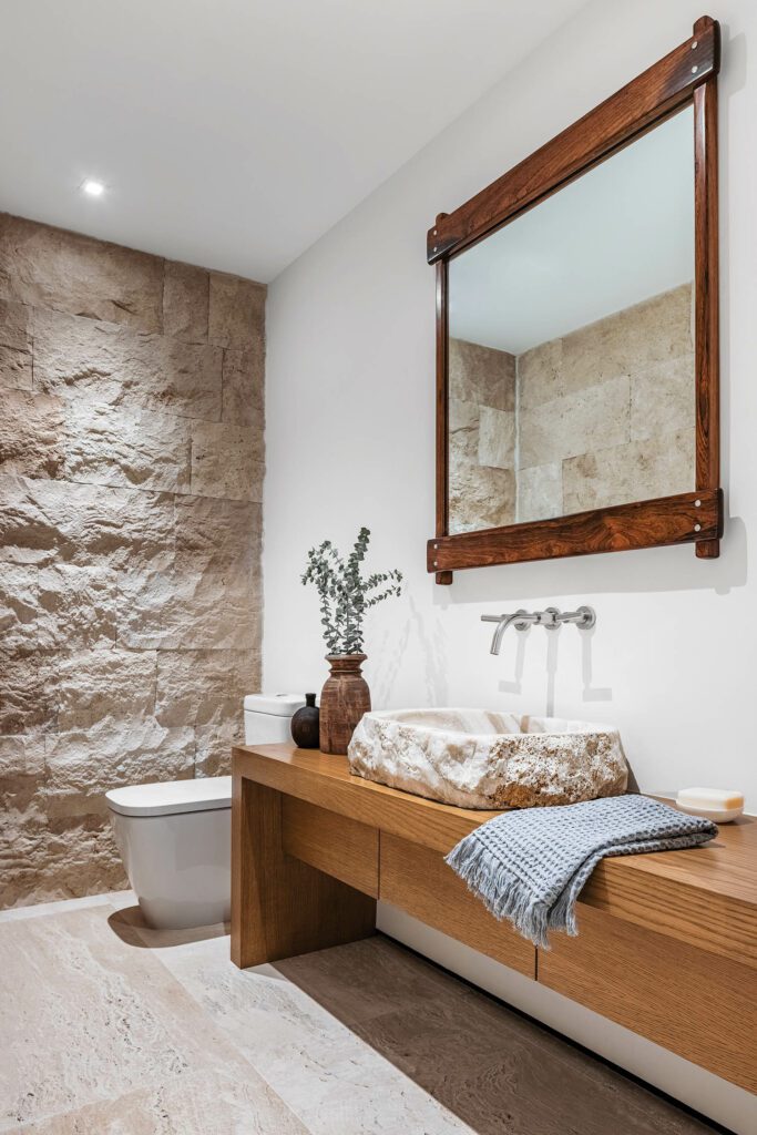 The wall and custom basin in the primary bath are the same Jersualem stone used on the house’s exterior.