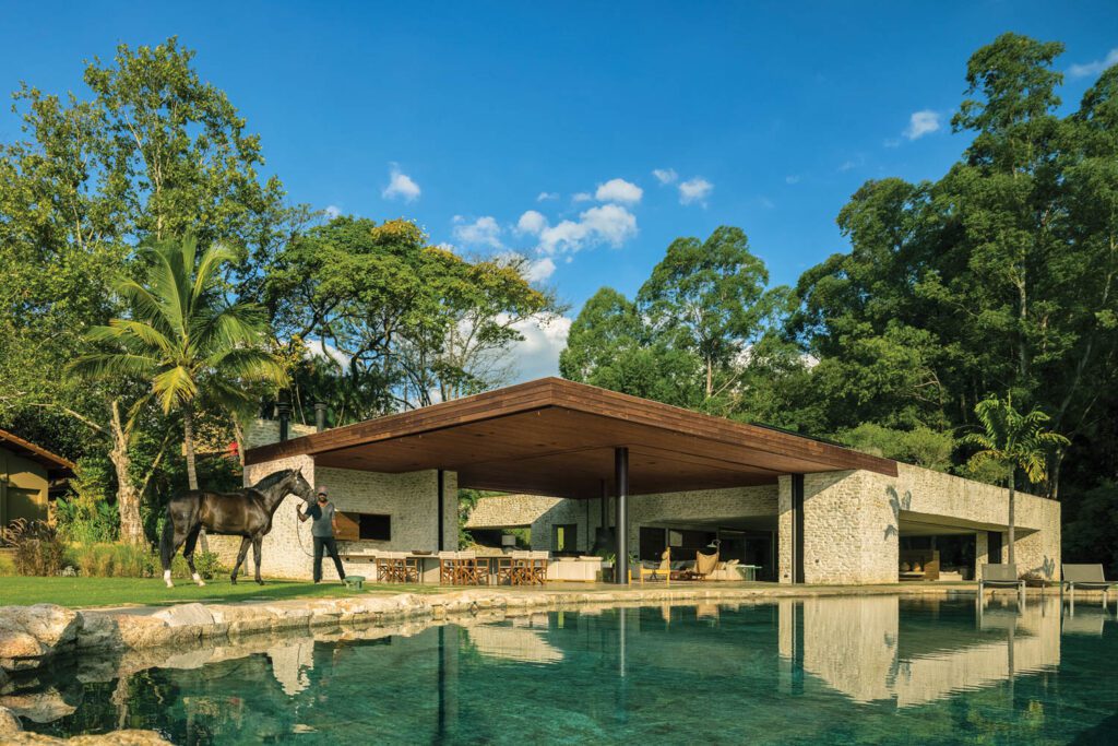 The pavilion roof extends to create a covered barbeque area overlooking the swimming pool.