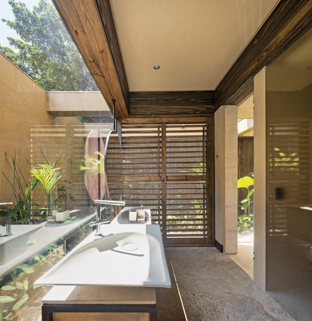 Surrounded by a screened garden, a guest bathroom is equipped with a Casas-designed sink and fittings.