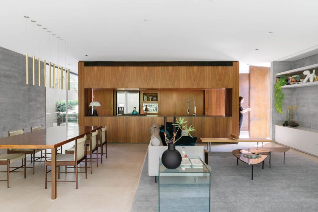 a dining area with table made of wood and steel next to a living area with a two-piece cocktail table